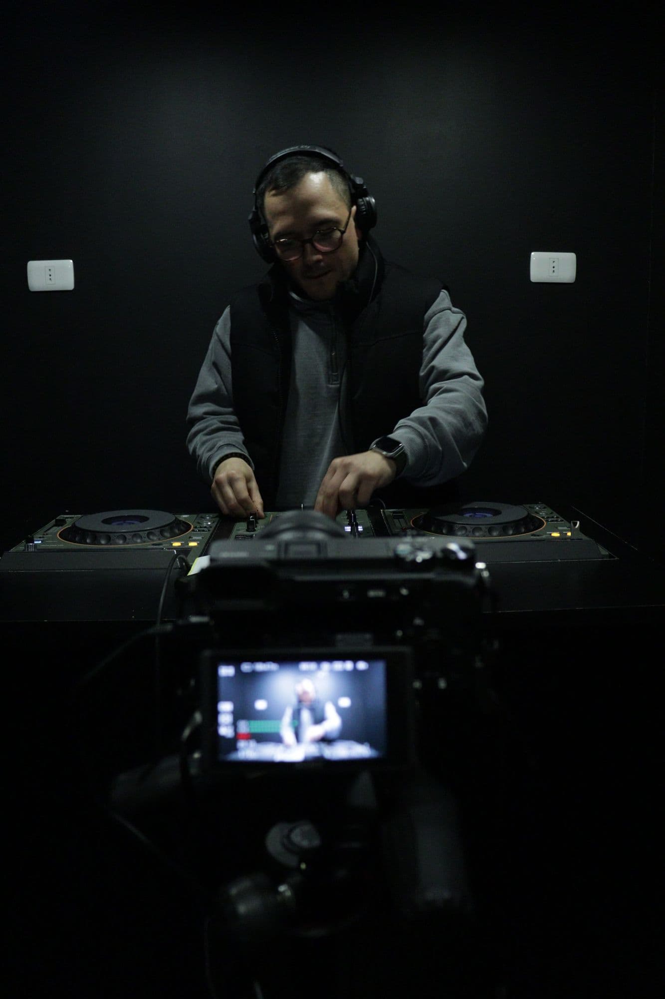 Manos mezclando en la XDJ-1000MK2 mientras la cámara graba la sesión